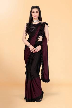Get glowing in this pretty ready-to-wear lycra saree. The colorblocked saree is made of lycra fabric in black and maroon color with ruffles detailing on hem beautified by brooch on shoulder making it more attractive. This saree comes along with unstitched velvet diamond embellished fabric blouse piece. It is perfect for parties, family functions when paired with beautiful jewellery and pair of heels to complete the look.