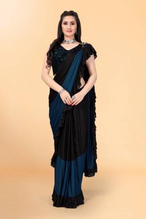 Get glowing in this pretty ready-to-wear lycra saree. The colorblocked saree is made of lycra fabric in black and teal color with ruffles detailing on hem beautified by brooch on shoulder making it more attractive. This saree comes along with unstitched velvet diamond embellished fabric blouse piece. It is perfect for parties, family functions when paired with beautiful jewellery and pair of heels to complete the look.
