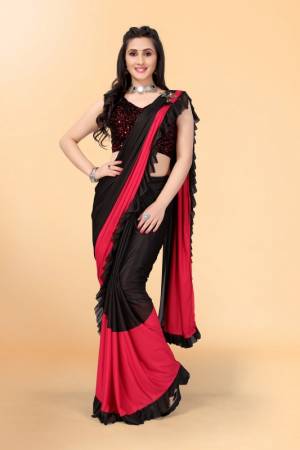 Get glowing in this pretty ready-to-wear lycra saree. The colorblocked saree is made of lycra fabric in black and red color with ruffles detailing on hem beautified by brooch on shoulder making it more attractive. This saree comes along with unstitched velvet diamond embellished fabric blouse piece. It is perfect for parties, family functions when paired with beautiful jewellery and pair of heels to complete the look.