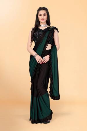 Get glowing in this pretty ready-to-wear lycra saree. The colorblocked saree is made of lycra fabric in black and green color with ruffles detailing on hem beautified by brooch on shoulder making it more attractive. This saree comes along with unstitched velvet diamond embellished fabric blouse piece. It is perfect for parties, family functions when paired with beautiful jewellery and pair of heels to complete the look.