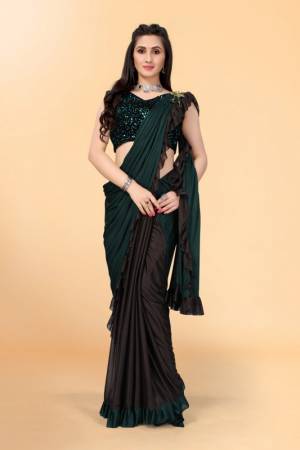 Get glowing in this pretty ready-to-wear lycra saree. The colorblocked saree is made of lycra fabric in black and green color with ruffles detailing on hem beautified by brooch on shoulder making it more attractive. This saree comes along with unstitched velvet diamond embellished fabric blouse piece. It is perfect for parties, family functions when paired with beautiful jewellery and pair of heels to complete the look.