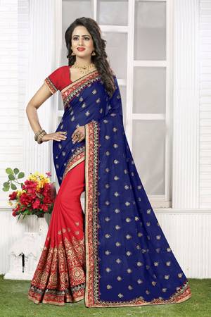 Colors Add Beauty To Any Outfit You Wear. Look Colorful In This Navy Blue And Red Colored Saree Paired With Red Colored Blouse. This Designer Saree Is Fabricated On Crush Chiffon Which Is Soft Towards Skin And Easy To Drape. Buy This Saree Now.