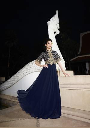 Here Is A Beautifully Patterned Designer Gown In Navy Blue Color Fabricated On Faux Georgette. It Is Beautified With Embroidery Over The Yoke And Bell Sleeves. Buy This Designer Readymade Gown Now.