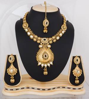Heavy Looking Necklace Set Is Here In Golden Color Beautified With White Colored Stones. This Lovely Set Can Be Paired With any Colored Traditional Attire. Buy It Now.