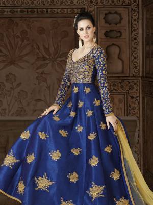 Shine Bright At The Next Party You Visit In This Attractive Royal Blue Colored Floor Length Dress Paired With Contrasting Light Yellow Colored Bottom And Dupatta. Its Top Is Fabricated On Art Silk Paired With Santoon Bottom And Net Dupatta. Its Heavy Embroidery Over the Yoke Is Making The Suit More Attractive.