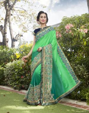 Add This Saree In Cool Color Pallete With Beautiful Shade Of Green Paired With Contrasting Navy Blue Colored Blouse. This Saree Is Fabricated On Satin Silk And Net Paired With Art Silk Fabricated Blouse. It Has Contrasting Embroidery Over It. Buy It Now.
