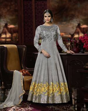 Here Is A Rich And Elegant Looking Floor Length Designer Suit In Grey Color Paired With Grey Colored Bottom And Dupatta. Its Top Is Fabricated On Art Silk Paired With Santoon Bottom And Chiffon Dupatta. It Has Tone To Tone Embroidery And Attractive Embroidery With Contrasting Yellow Color. Buy This Designer Suit Now.