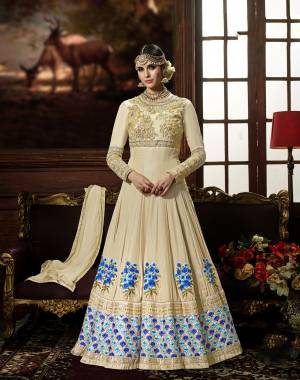 This Wedding Season, Adorn This Lovely Designer Floor Length Suit In Cream Color Paired With Cream Colored Bottom And Dupatta. Its Top Is Fabricated On Crepe Silk Paired With Santoon Bottom And Chiffon Dupatta. It Has Embroidery Yoke And Contrasting Embroidery Over The Panel. Buy Now.