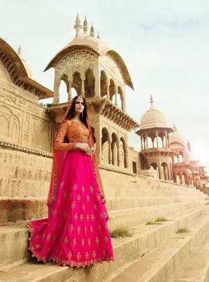 Shine Bright Wearing This Designer Lehenga Choli In Orange Colored Blouse Paired With Contrasting Rani Pink Colored Lehenga And Shaded Orange And Pink Dupatta. This Lehenga And Choli Are Fabricated On Art Silk Paired With Net fabricated Dupatta. Its Fabrics Ensures Superb Comfort All Day Long. Buy It Now.