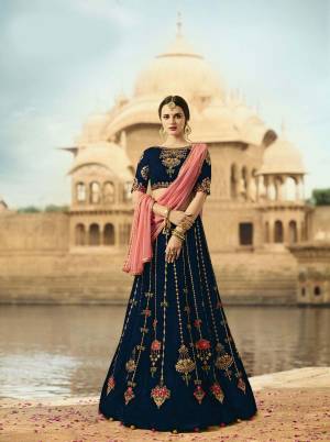 Enhance Your Personality Wearing This Lehenga Choli In Navy Blue Color Paired With Contrasting Pink Colored Dupatta. This Lehenga And Choli Are Fabricated On Velvet Paired With Net Fabricated Dupatta. This Velvet Fabrics Gives You A Rich And attractive Look To Your Personality.