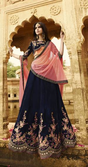 Enhance Your Personality Wearing This Lehenga Choli In Navy Blue And Beige Colored Blouse Paired With Navy Blue Colored Lehenga Paired With Contrasting Pink Colored Dupatta. This Lehenga And Choli Are Fabricated On Velvet Paired With Net Fabricated Dupatta. This Velvet Fabrics Gives You A Rich And attractive Look To Your Personality.