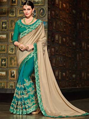 Vibrant and visually appealing, this beige and teal green color two-tone silk fabrics saree. Ideal for party, festive & social gatherings. this gorgeous saree featuring a beautiful mix of designs. Its attractive color and designer floral design, stone work over the attire & contrast hemline adds to the look. Comes along with a contrast unstitched blouse.