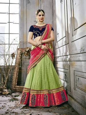 Go Colorful Wearing this Designer Lehenga Choli In Navy Blue Colored Blouse Paired With Green Colored Lehenga And Contrasting Pink Colored Dupatta. Its Blouse Is Fabricated On Velvet Paired With Net Fabricated Lehenga And Dupatta. This Lehenga Choli Is Light In Weight And Easy To Carry All Day Long. 