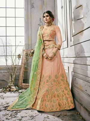 Most Demanding Color Of The Season Is Here With Beautiful Peach Colored Designer Lehenga Choli Paired With Contrasting Light Green Colored Dupatta. Its Lehenga And Choli Are Fabricated On Satin Silk Paired With Net Fabricated Dupatta. Wear This Designer Lehenga At The Next Wedding At Your Place And Earn Lots Of Compliments From Onlookers.