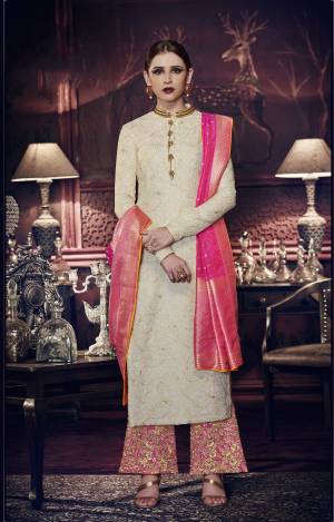 Flaunt Your Rich And Elegant Taste Wearing This Designer Straight Cut Suit In Off-White Colored Top Paired With Pink Colored Bottom And Dupatta. Its Top Is Fabricated On Tussar Art Silk Paired With Santoon Bottom And Jacquard Silk Dupatta. Its Rich Fabric And Heavy Embroidery Will Earn You Lots Of Compliments From Onlookers. Buy This Designer Suit Now. 