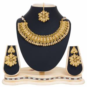 Get This Pretty Necklace In Golden Color Which Comes With Earrings And A Maang Tika. As It Is Beautified With Beige Colored Stones. It Can Be Paired With Any Colored Traditonal Attire. Buy This Set Now.