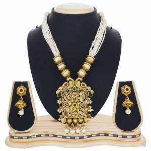 Proper Traditional Necklace Set In Here In Golden Colo Beautified with Multi Colored Stones And Has Multi Layered Chains Of Small Pearls. This Necklace Set Looks Best With Any Silk Saree.