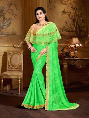 Add This Designer Saree To Your Wardrobe In Green Color Paired With Contrasting Peach Colored Blouse And Green Colored Cape. This Saree Is Fabricated On Georgette Brasso Paired With Crepe Blouse And Net Cape. All Its Fabrics Are Light Weight And Easy To Carry All Day Long.