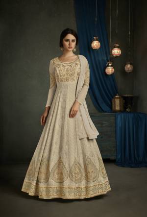 Flaunt Your Rich And Elegant Taste Wearing This Designer Floor Length Suit In Cream Color Paired With Cream Colored Bottom And Dupatta. Its top Is Fabricated On Georgette Paired With Santoon Bottom And Chiffon Dupatta. It Has Very Detailed And Beautiful Embroidery All Over Its Top. Buy This Pretty Rich Suit Now.