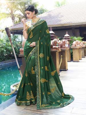 Add This Very Pretty Shade Of Green With This Saree In Dark Green Color Paired With Beige Colored Blouse. This Saree Is Fabricated On Chiffon Silk Paired With Art Silk Fabricated Blouse. It Has Attractive Golden Embroidered Motifs Over The Saree. Buy Now.