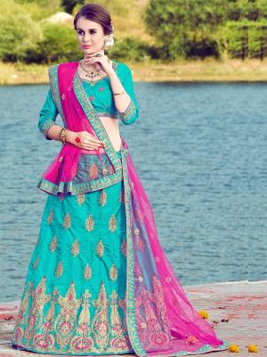 You Will Definitely Earn Lots Of Compliments Wearing This Designer Lehenga Choli In Turquoise Blue Color Paired With Contrasting Rani Pink Colored Dupatta. Its Blouse And Lehenga Are Fabricated On Art Silk Paired With Net Fabricated Dupatta. It Is Light Weight And Easy To Carry All Day Long. 