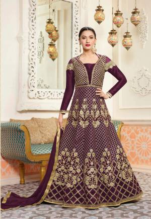 A Must Have Shade In Every Womens Wardrobe Is Here With This Designer Floor Length Suit In Wine Color Paired With Wine Colored Bottom And Dupatta. Its Top Is Fabricated On Art Silk Paired With Santoon Bottom And Chiffon Dupatta. Its Pretty Color And Heavy Embroidery Will Earn You Lots Of Compliments From Onlookers. 