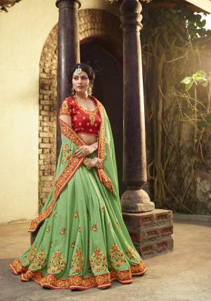 Here Is A Beautiful Designer Saree In Light Green Color Paired With Contrasting Red Colored Blouse. This Saree And Blouse Are Fabricated On Art Silk Beautified With Heavy Embroidery All Over It. Buy This Saree Now.