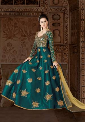 Shine Bright At The Next Party You Visit In This Attractive Teal Blue Colored Floor Length Dress Paired With Beige Colored Bottom And Dupatta. Its Top Is Fabricated On Art Silk Paired With Santoon Bottom And Net Dupatta. Its Heavy Embroidery Over the Yoke Is Making The Suit More Attractive.