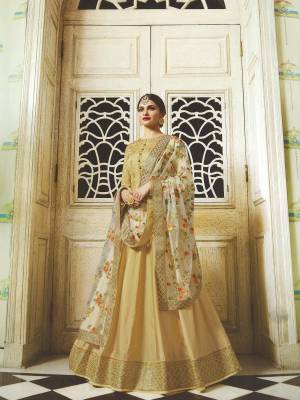 Grab This Designer Floor Length Suit In Golden Colored Top Paired With Golden Colored Bottom And Off-White Colored Dupatta. Its Top Is Fabricated OnArt Silk Which Gives A Rich Look To Your Personality Paired With Santoon Bottom And Net Fabricated  Heavy Embroidered Dupatta. Buy It Now.