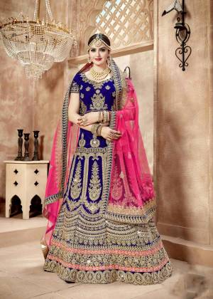 Shine Bright Weraring This Designer Lehenga Choli In Royal Blue Colored Paired With Two Different Dupattas, One Is In Royal Blue And Another In Fuschia Pink Color. Its Blouse And Lehenga Are Fabricated On Velvet Paired With Paired With Net Fabricated Both Dupattas. It Has Heavy Jari Embroidery All Over It.