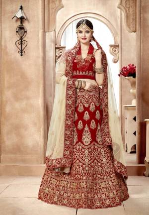 For A Royal Queen Like Look, Grab This Designer Lehenga Choli In Maroon Color Paired With Contrasting Cream Colored Dupatta And Another Maroon Colored Dupatta. Its Blouse And Lehenga Are Fabricated On Velvet Paired With Net Fabricated Dupattas. Buy Now.