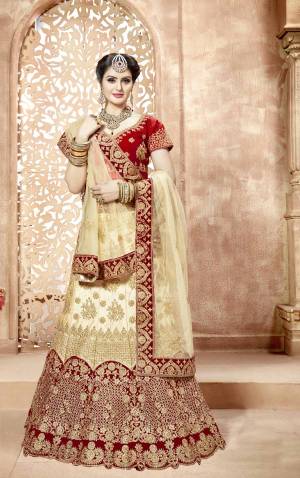 Evergreen Traditional Combination Is Here With This Designer Lehenga Choli In Red Colored Blouse, Paired With Cream Colored Lehenga And Dupatta And Its Another Dupatta Is In Red Color. Its Blouse IS Fabricated On Art Silk Paired With Nylon Satin Lehenga And Net Fabricated Dupattas. Buy This Heavy Designer Lehenga Choli Now.