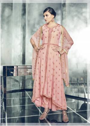 A Must Have Color In Every Womens Wardrobe, Grab This Beautiful Designer Indo-Western Suit In Peach Color Paired With Peach Colored Bottom And Dupatta. Its Top Is Fabricated On Net Paired with Santoon Bottom And Net Dupatta. Additonally This Dress Comes With A Lehenga And Jacket. Buy Now.