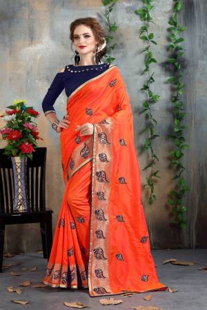 Orange Color Induces Perfect Summery Appeal To Any Outfit, So Grab This Attractive Saree In Orange Color Paired With Contrasting Navy Blue Colored Blouse. This Saree And Blouse Are Fabricated On Art Silk Beautified With Attractive Jari And Thread Embroidery. Buy Now.