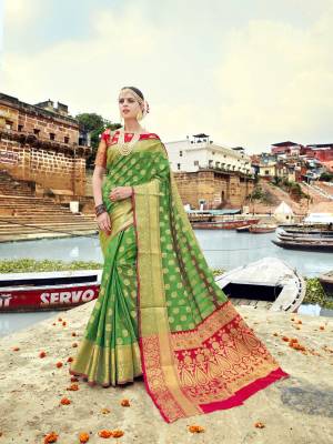 Celebrate This Festive Season Wearing This Saree In Green Color Paired With Contrasting Red Colored Blouse. This Saree And Blouse Are Fabricated On Banarasi Art Silk Beautified With Weave All Over It. Buy This Rich Looking Saree Now.