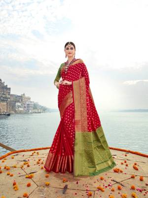 Adorn The Pretty Angelic Look Wearing This Saree In Red Color Paired With Contrasting Green Colored Blouse. This Saree And Blouse Are Fabricated On Banarasi Art Silk Beautified With Weave All Over. 