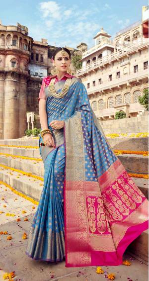 Look Pretty Wearing This Silk Saree In Turquoise Blue Color Paired With Contrasting Dark Pink Colored Blouse. This Saree And Blouse Are Fabricated On Banarasi Art Silk Beautfiied With Weave All Over. Its Pretty Color Combination And Weave Will Give A Very Pretty Look To Your Personality.
