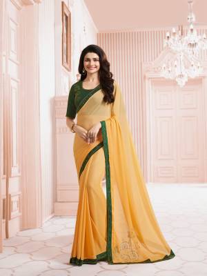 Have Bright Look This Summer Wearing This Saree In Yellow Color Paired With Contrasting Pine Green Colored Blouse. This Saree Is Fabricated On Georgette Paired With Art Silk Fabricated Blouse. It Is Beautified With Stone Work. Buy This Saree Now.