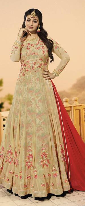 Flaunt Your Rich And Elegant Taste Wearing This Designer Floor Length Suit In Beige Colored Top Paired With Beige Colored Bottom And Red Colored Dupatta. Its Top Is Fabricated On Georgette Paired With Santoon Bottom And Chiffon Dupatta. It Is Beautified With Embroidery All Over The Top. Buy now.