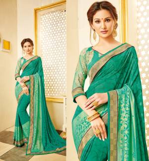 Celebrate This Festive Season Wearing This Designer Saree In Green Color Paired With Green Colored Blouse. This Saree Is Fabricated On Georgette Paired With Net Fabricated Blouse. It Has Embroidery Over The Blouse And Saree IS Beautified With Lace Border And Prints.
