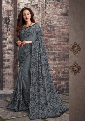 Adorn The Pretty Angelic Look Wearing This Saree In Grey Color Paired With Grey Colored Blouse. This Saree And Blouse Are Fabricated On Chiffon Beautified With Simple Floral Prints All Over It. This Saree Is Light In Weight And Also Easy To Carry All Day Long. 