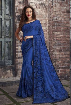 Adorn The Pretty Angelic Look Wearing This Saree In Royal Blue Color Paired With Royal Blue Colored Blouse. This Saree And Blouse Are Fabricated On Chiffon Beautified With Simple Floral Prints All Over It. This Saree Is Light In Weight And Also Easy To Carry All Day Long. 