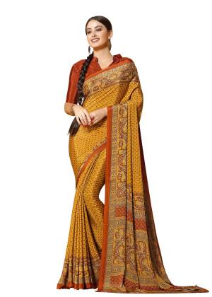 A Proper Traditonal Combination Is Here With This Saree In Yellow Color Paired With Contrasting Rust Orange Colored Blouse. This Saree And Blouse Are Fabricated On Crepe Beautified With Prints All Over It. Buy This Saree Now.