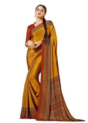 A Proper Traditonal Combination Is Here With This Saree In Musturd Yellow Color Paired With Contrasting Rust Orange Colored Blouse. This Saree And Blouse Are Fabricated On Crepe Beautified With Prints All Over It. Buy This Saree Now.