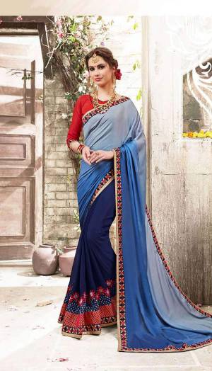 Shades Are Always In, So Grab This Beautiful Shaded Saree In Light And Dark Blue Shades Paired With Contrasting Red Colored Blouse. This Saree Is Fabricated On Satin And Georgette Paired With Art Silk Fabricated Blouse. Buy This Saree Now.