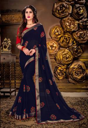 Enhance Your Personality Wearing This Saree In Navy Blue Color Paired With Contrasting Red Colored Blouse. This Saree Is Fabricated On Georgette Paired With Art Silk Fabricated Blouse. It Is Beautified With Floral Printed Motifs. Buy This Saree Now.