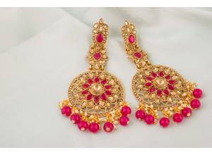 Here Is A Very Pretty Pair Of Earrings In Golden Color Beautified With Dark Pink Colored Stone Work. You Can Pair This Up With Pink Or Any Contrasting Colored Ethnic Attire. Buy Now.
