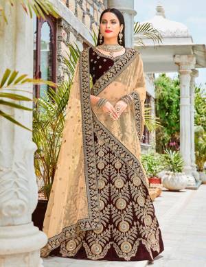 Get Ready For The Upcoming Wedding Season With This Heavy Designer Lehenga Choli In Brown Color Paired With Beige Colored Blouse. Its Blouse And Lehenga Are Fabricated On Velvet Paired With Net Fabricated Dupatta. This Designer Lehenga Choli Is Beautified With Heavy Jari And Thread Embroidery. Buy This New Color Now.