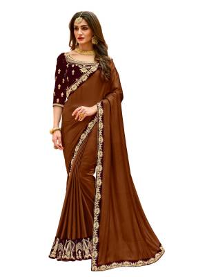 Rich and Elegant Lookin Designer Saree Is Here In Brown Color Paired With Contrasting Maroon Colored Blouse. This Saree Is Fabricated On Satin Silk Paired With Velvet Fabricated Blouse. It Has Embroidery Over The Designer Blouse And Embroidered Lace Border Over The Saree.