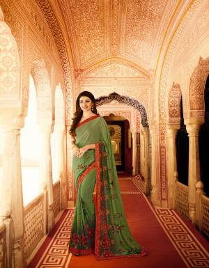For Your Casual Or Semi-Casual Wear, Grab This Traditional Colored Saree In Green Paired With Contrasting Red Colored Blouse. This Saree Is Fabricated On Georgette Paired With Art Silk Fabricated Blouse. It Is Beautified With Prints All Over.